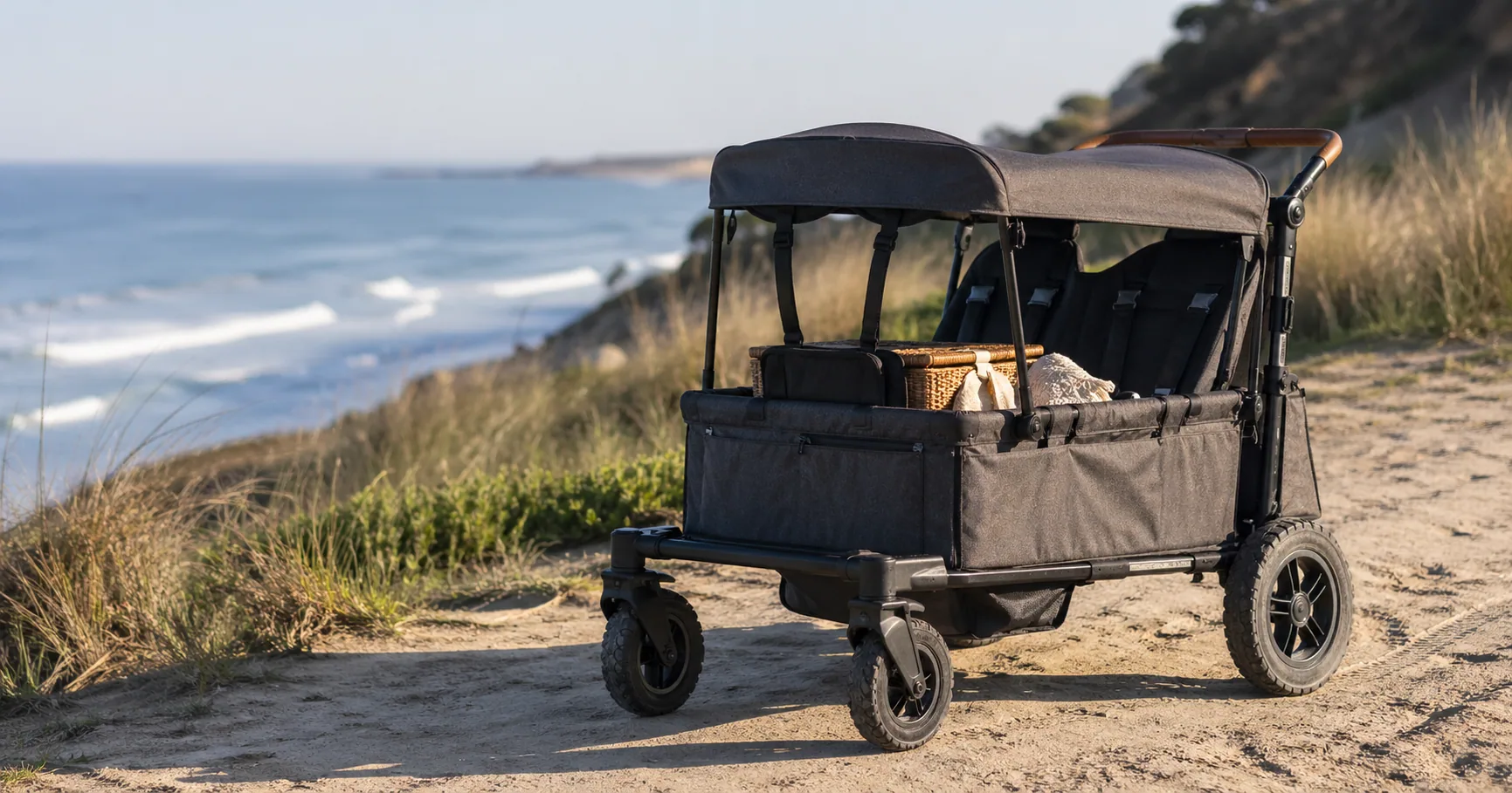 All-terrain stroller wagon with two children parked on a sandy beach path